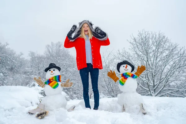 Joyeux hiver fille faisant bonhomme de neige. Noël excité les gens en plein air. Enfant heureux jouant avec un bonhomme de neige lors d'une promenade hivernale enneigée . — Photo