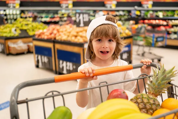 Kleinkind mit Einkaufstasche im Supermarkt. Kind kauft im Supermarkt ein. — Stockfoto