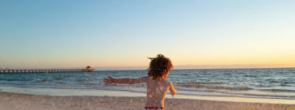 Panoramafoto von Kindern, die mit Sand am Sommerstrand spielen. Glücklicher Junge, der im Meer spielt. Kinder haben Spaß im Freien. Sommerferienkonzept. — Stockfoto