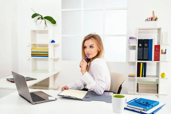 Schoonheidsspecialiste op kantoor. Prachtige blonde secretaresse vrouw opschrijven notities in klembord tijdens het werken in het kantoor. — Stockfoto