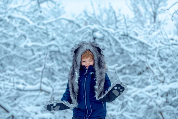 Enfant d'hiver. Petit garçon marchant dans le champ d'hiver. Concept hiver Enfants et nature. Souvenirs d'enfance - bel hiver enneigé sur prairie . — Photo