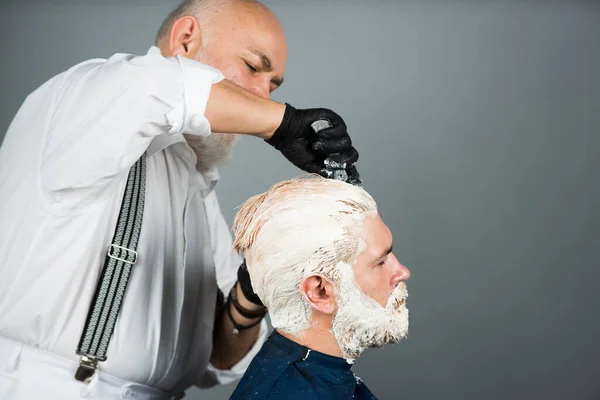 Tintura per capelli cliente uomo. Salone da parrucchiere. Applicazione di cosmetici. Colorazione dei capelli in un salone di bellezza . — Foto Stock