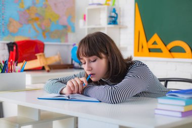 Genç, beyaz tahtaya yazı yazıyor. Öğrenci. Üniversitede bir kız öğrencinin portresi. Üniversitede ödev yapmayı düşünen kız öğrenci.