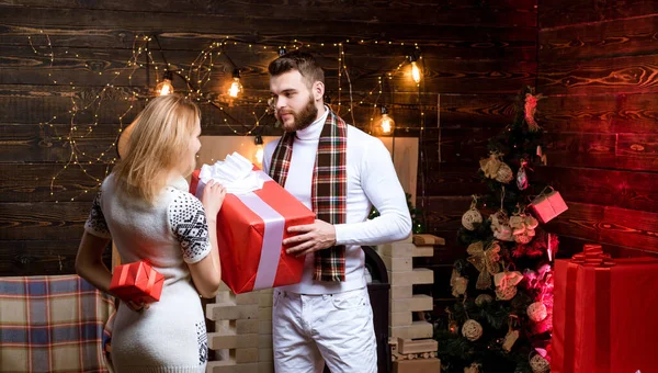 Ρούχα μόδας της Πρωτοχρονιάς. Γυναίκα και άντρας δίνουν δώρα ο ένας στον άλλον. Χριστουγεννιάτικο ζευγάρι ερωτευμένο. — Φωτογραφία Αρχείου