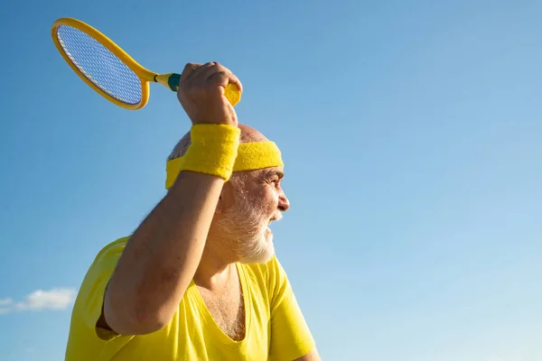 Tennis macht Spaß. Tennis-Senior-Spieler beim Aufschlag. Gesund und Sport. Sport und Rentenkonzept. — Stockfoto