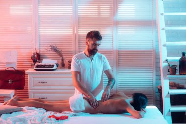 Rahatlatıcı genç çift evde masaj yapıyor. Güzel seksi bir çiftin moda portresi. Seksi çift aşk oyunlarında oynar. Erkek, evde kadına erotik masaj yapıyor. Tutku ve şehvetli dokunuş.