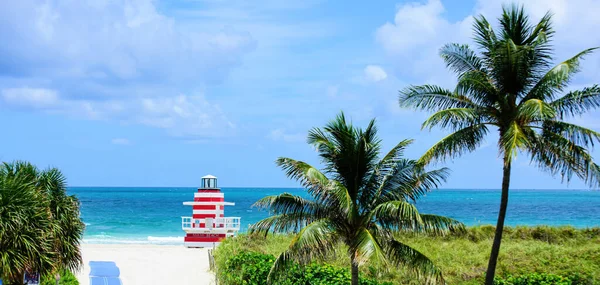 Miami Beach con torre salvavidas y costa con nubes de colores y cielo azul. Fondo del océano Atlántico . — Foto de Stock