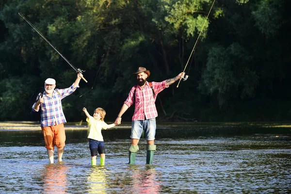 Pescatori. Un legame familiare. Ragazzo con padre e nonno pesca a mosca all'aperto sullo sfondo del fiume. L'uomo insegna ai bambini a pescare nel fiume . — Foto Stock