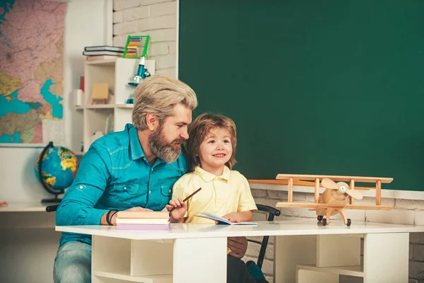 Modelos de asociación escolar comunitaria. Aula de la escuela primaria. Alumnos Educación. Proceso educativo. Lindo alumno y su padre escolarización trabajo . — Foto de Stock