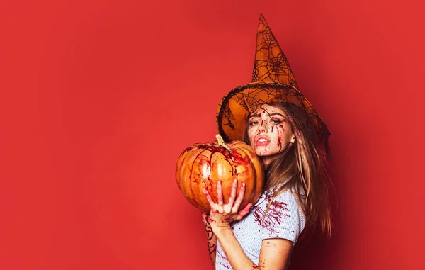 Chica con calabaza. Mujer de Halloween sobre fondo rojo aislado. Sangre en la cara. Maldito Halloween. . — Foto de Stock