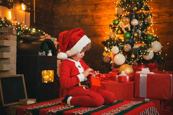 Malý Santa Claus pomocník elf s kouzelným darem na Vánoce. Vánoce. Santa malý pomocník. Šťastný rodinný koncept. Malý génius. Malý chlapec v Santově klobouku a v kostýmu se baví. Nový rok. — Stock fotografie