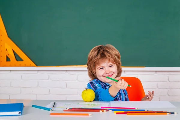 Cute pupil with funny face schooling work. Portrait of Pupil in classroom. Elementary school and education. Individual tutoring.