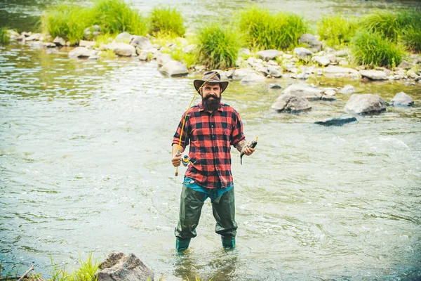 Pescador guapo con sombrero y camisa roja a cuadros. La pesca como vacaciones. Hombre relajante naturaleza fondo. No es deporte, es obsesión. Maestro cebo. Es tan grande. Pesca. —  Fotos de Stock