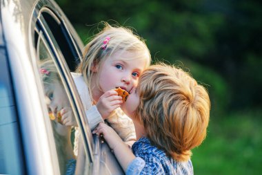 Küçük oğlan tatlı kız için öpücük verir. Güle güle. Araba yolculuğundan önce küçük komik bir çift hoşça kal diyor. Elveda çocuk konsepti..