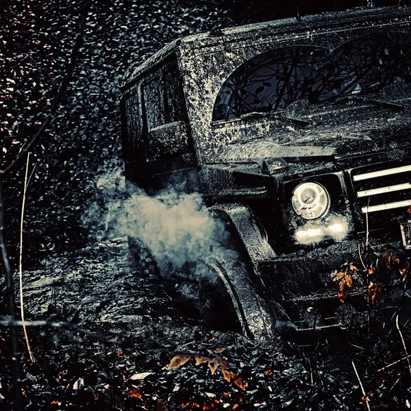 Veículo offroad saindo de um perigo de buraco de lama. Aventura na estrada. Viagem de aventura. Mudding é off-roading através de uma área de lama molhada ou argila. Conceito de viagem com carro grande 4x4 . — Fotografia de Stock