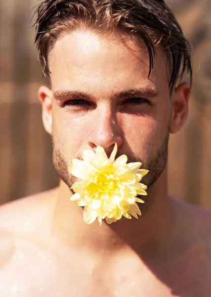 Verliefde man. Trots homoseksueel concept. Man gezicht met bloem in mond, tong. Knappe man close-up portret. — Stockfoto