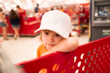 Komik çocuklar alışveriş yapıyor. Süpermarketteki neşeli, güzel çocuk sebze alıyor. Çocuklar için sağlıklı yiyecekler.