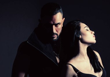 Kaslı adam. Karanlık arka planda aşık bir çift. Rahat ol. Güzel bir çiftin moda stüdyosu fotoğrafı. Aşık çift. Genç ve seksi bir çift. Onunla ilgili her şeyi seviyorum. Sevgi. Güzel genç aşıklar.