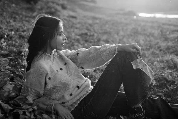 Profilo ritratto di bella donna bruna al bellissimo tramonto della sera autunnale. La madre giovane riposa a foglie cadute a panchina fluviale. Maternità e concetto di natura autunnale . — Foto Stock