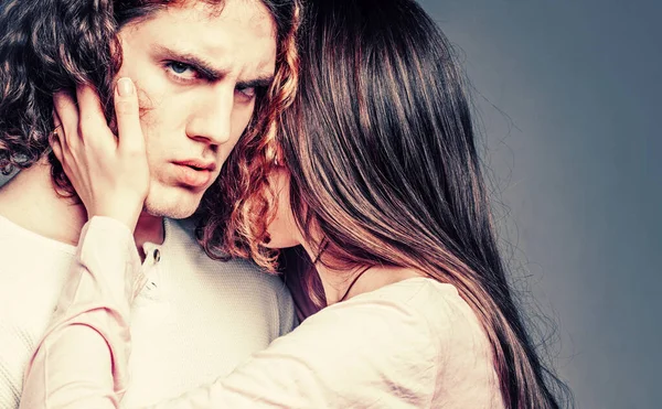 Attractive young couple hugging each other on grey background. Young man and woman in cuddle. Young sexy couple. Close up photo. Love and trust. Pose for family portrait. Love.