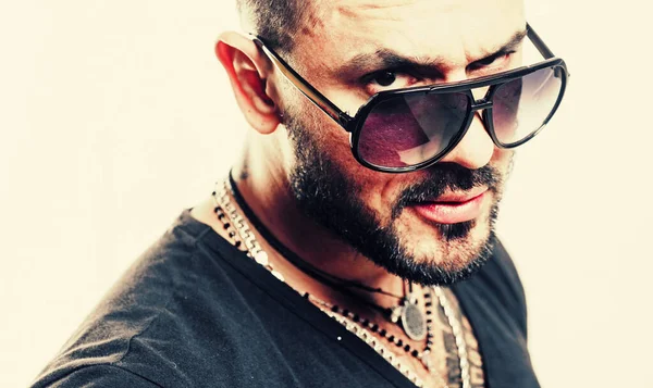 Bearded guy with glasses. Close-up portrait of serious man model with mustaches and beard in sunglasses and shirt.