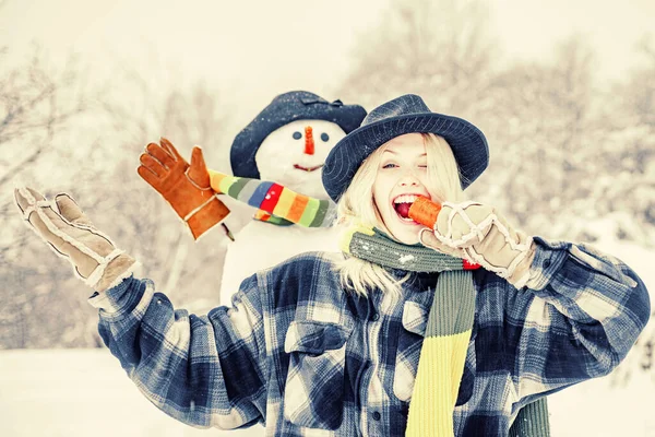 Snowman with funny carrot nose with fun girl. Fashion portrait of young model girl indoors with Christmas snowman. Christmas preparation - funny girl make snowman. — 스톡 사진