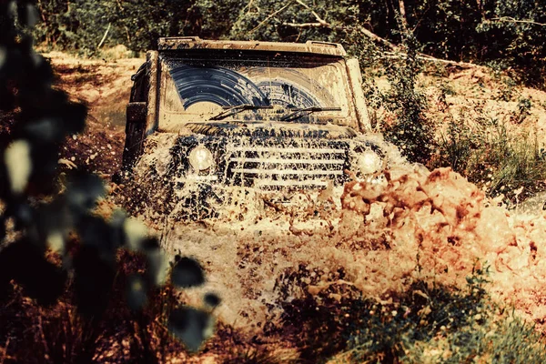 Veículo off-road vai para a montanha. Mudding é off-roading através de uma área de lama molhada ou argila. Vestígios num campo lamacento. Rastrear na lama. 4x4 Off-road carro SUV. Carro desligado. Safari . — Fotografia de Stock