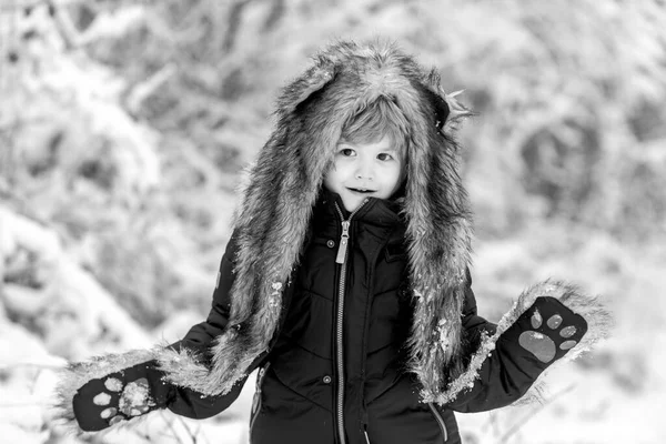 Niños con ropa de invierno. Lindo niño disfrutando en el parque de invierno en la nieve. Chico divertido que viene al bosque de invierno en el paisaje de nieve . —  Fotos de Stock