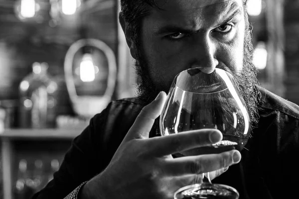 Man drinks brandy or whiskey. Bearded man wearing suit and drinking whiskey brandy or cognac. Sommelier tastes alcohol drink. Drinking and party concept. Degustation and tasting. — Stock Photo, Image
