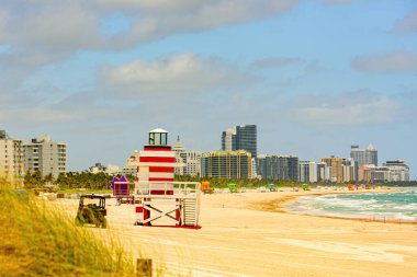 Cankurtaran kulesi ve renkli bulutlu ve mavi gökyüzü olan bir sahil. Miami Plajı 'ndaki Cankurtaran Karakolu. Sandy Tropikal Sahnesi.