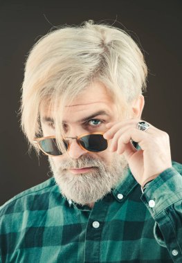 Yakışıklı bir adamın moda tarzı portresi. Kafkas görünümlü yetişkin bir adamın portresi gri arka planda izole edilmiş..