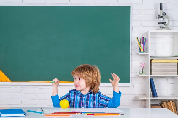 Bambino vicino alla lavagna in classe scolastica. Ragazzi felici a lezione. Istruzione scolastica e concetto di persone - allievo carino su sfondo lavagna. — Foto Stock