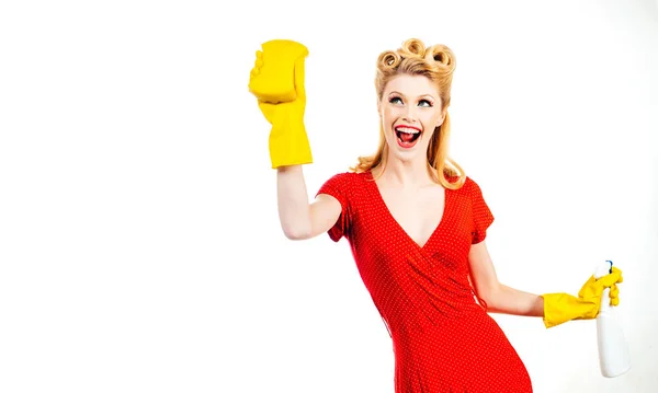 Concept de nettoyage. Jeune femme tient des liquides de lavage et des chiffons dans les mains sur fond blanc, isolé. Belle jeune femme utilise un plumeau et un spray, regardant la caméra et souriant. — Photo