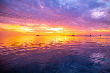 Tropik plajda gün batımı. Sabahın erken saatlerinde, denizin üstünde gün doğarken.