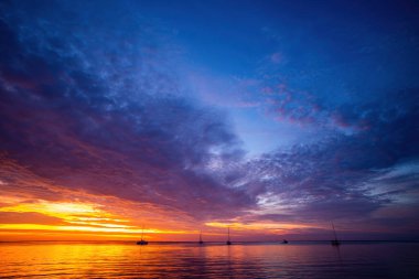 Okyanusta ya da denizde gün batımı ya da gün doğumu, doğa manzarası. Gün batımı sahili. Mavi deniz ve güneş ışığının yansıması.