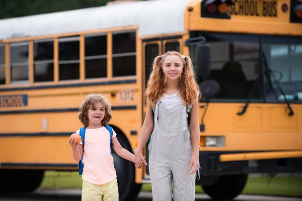 Foto von zwei glücklichen Kindern, die aus den Fenstern eines gelben Schulbusses schauen. Viel Platz für Text. — Stockfoto