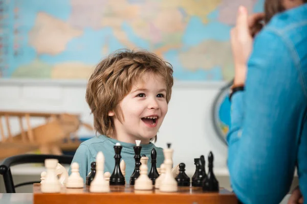 Schaakschool voor kinderen. Vrolijk lachend jongetje aan tafel en opgewekte blijdschap tijdens het schaken. — Stockfoto