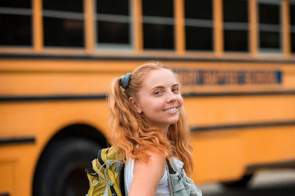 Happy girl on school bus excited for first day of school. Happy school teen. Education.