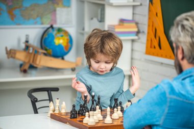 Konsantre çocuk satranç stratejisi geliştiriyor, masa oyunu oynuyor. Düşünen çocuk. Satranç, başarı ve kazanmak..
