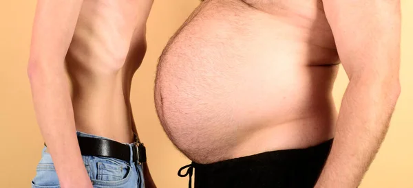 Uomo obeso grasso corporeo in vita. Uomo con figura grassa e sottile su sfondo giallo. Anoressia vs Fat problema. — Foto Stock