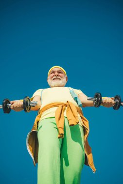 Yaşlı, olgun bir adam halterle egzersiz yapıyor. Spor merkezinde kıdemli sporcu. Spor gibi. Egzersiz sonrası yaşlı adam..