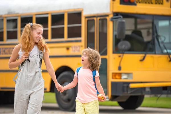 Zurück zur Schule. Grundschüler im Schulbus. Wenig bereit zum Studium. Glückliches Geschwisterpaar steht gemeinsam vor Schulbus. — Stockfoto