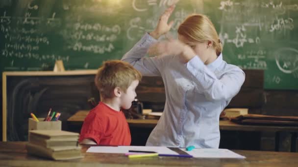 Glückliche Mutter und lächelnder Sohn beim gemeinsamen Lernen. Mutter hilft Kind bei den Hausaufgaben. Mutter und kleiner Junge gehen zu Hause zur Schule. Heimatstudie. Bildungsprozess. — Stockvideo