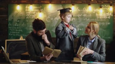 Ebeveyn ve evde eğitim. Okul kitaplarıyla ödev yapan komik genç öğrenci. Çocuklar evde ödev yapıyor. Sevgi dolu bir aile. Çocukluk ve eğitim kavramı.