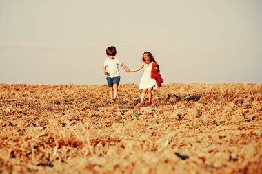 Doğadaki sevimli arkadaşlar için güzel eğlenceli bir gün. Çocukların yaz neşesi vardır. Çocuklar dışarıda oynar. Dışarıda eğlenirken. Pozitif küçük kız ve oğlan. Dışarıdaki küçük çocuk.