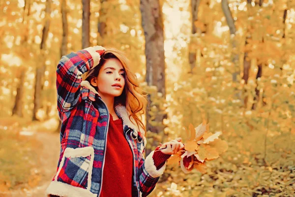 Höstkvinna i höstparken med röd stoppare. Höstflicka. En romantisk flickas konstverk. Varmt soligt väder. Hösten utomhus porträtt av vacker glad flicka promenader i park eller skog i varm stickad — Stockfoto