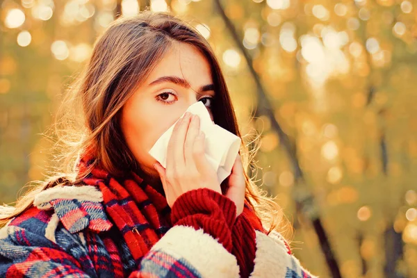 Mujer con servilleta estornudando en el parque amarillo. La gente enferma tiene secreción nasal. Temporada de alergia. La mujer cura el resfriado común. Mujer hace una cura para el resfriado común en el parque de otoño . — Foto de Stock