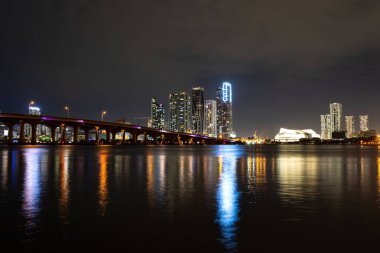 Miami şehir merkezinde. Miami Florida, gün batımı manzarası. Biscayne Körfezi 'nde renkli iş yerleri, konut binaları ve köprü..