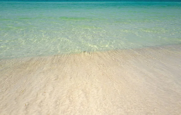 Ola del mar en la playa de arena. Playa de arena con fondo azul océano y paisaje nublado. Panorama marino. Océano tropical y playa . — Foto de Stock