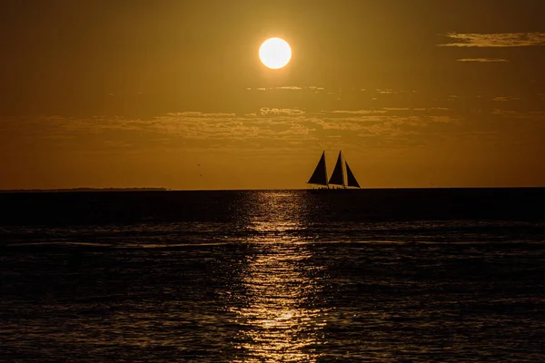 Ocean sunset sailboat sailing along the ocean water at sunset. Sailing at sunset. — Stock Photo, Image
